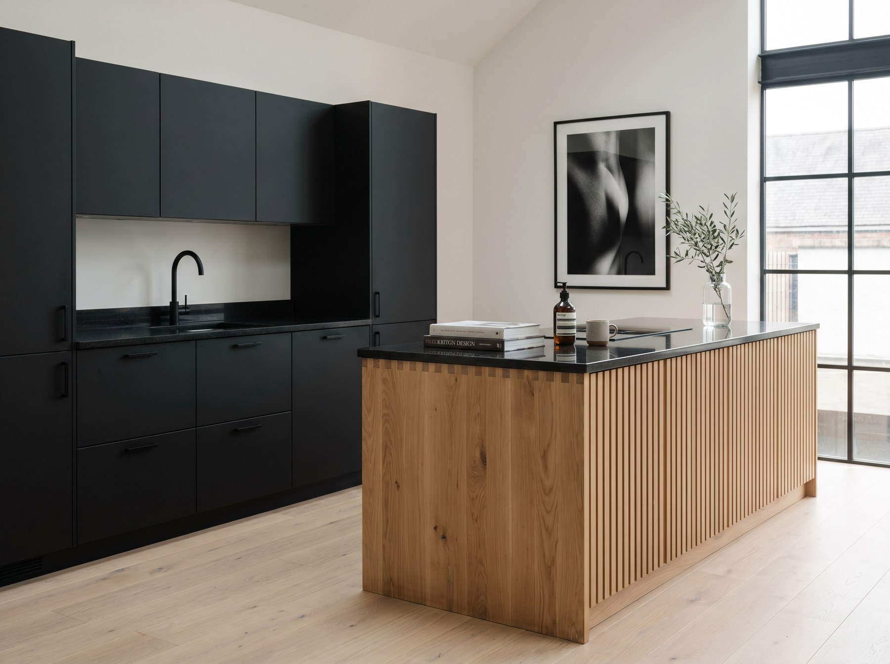 Reeve & Co Scandi kitchen with matt black handle-less slab cabinetry contrasted by a raw oiled oak slatted island in a loft-style space