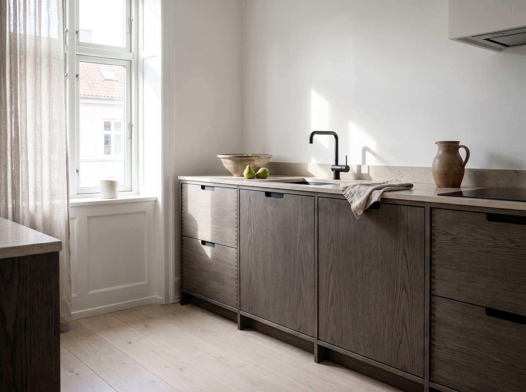 Reeve & Co Scandi kitchen in smoked oak finger-jointed slab cabinetry with pale honed limestone worktop and matt black tap